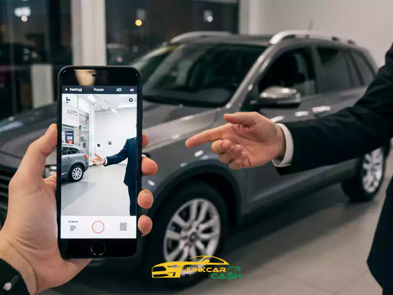 Person takes a photo of a grey SUV inside a car dealership showroom.